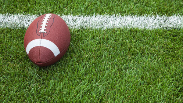 A college football at the goal line on a grass field