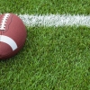 A college football at the goal line on a grass field