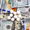 USA national currency, top view of mixed American dollars banknotes with white pills on it, drugs, money laundering, cartel, expensive medicine concepts. Top view
