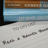To do list reminder to read a banned book, along with a pile of books frequently on censorship lists.