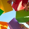 School children read books outdoors and learn about nature. Group of students standing in circle and holding red, green, yellow, orange and purple books in hands. Low angle bottom view shot from below