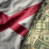 colorful waving national flag of alabama state on a american dollar money background. finance concept