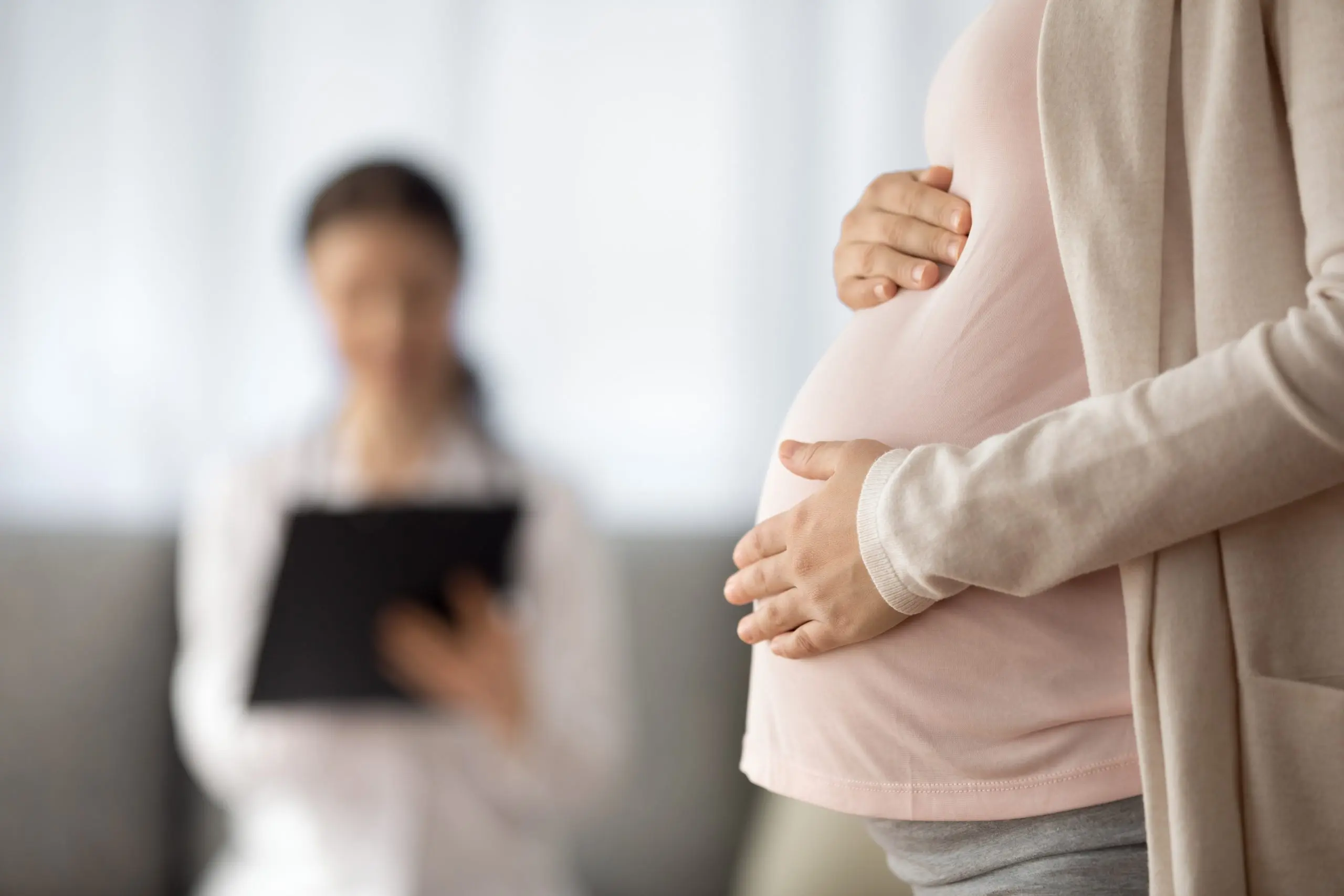Close up of woman expecting baby having appointment with doctor
