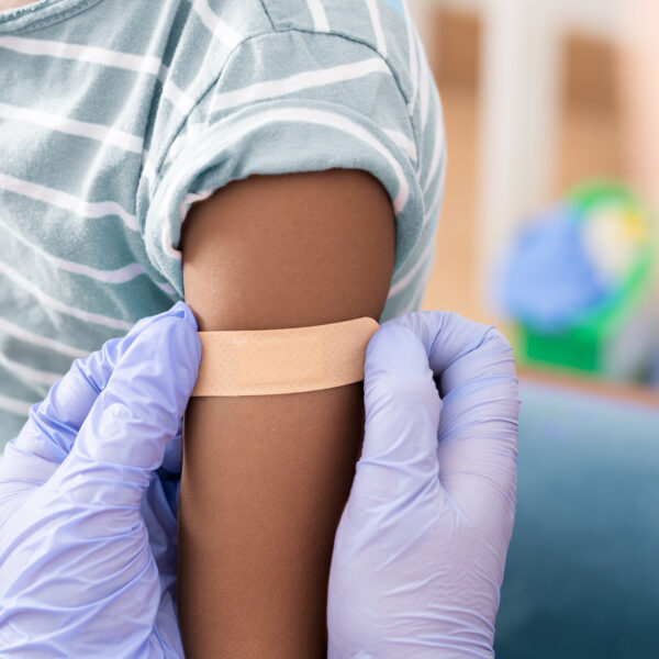 Doctor, medical and insurance with a child in a clinic for his vaccination.